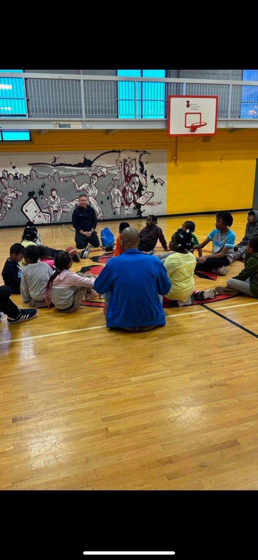 John mentoring kids at a community basketball program